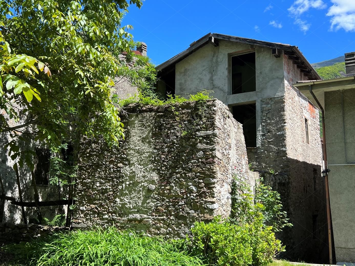 Complesso residenziale al rustico di 242 mq composto da quattro appartamenti e villetta a schiera laterale in Cortenova