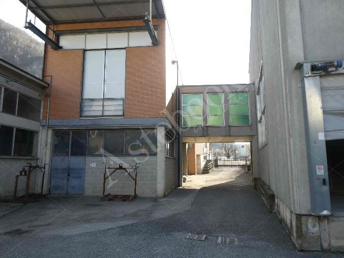 Capannone industriale ad uso produttivo con area esterna e porzione di parcheggio esterno in Valmadrera