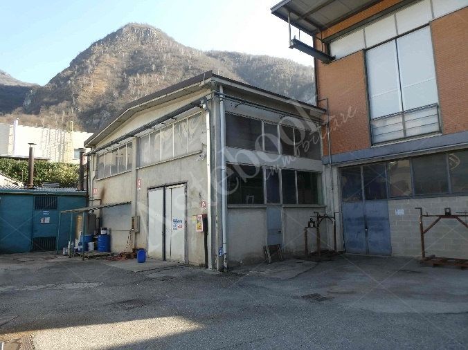 Capannone industriale ad uso produttivo con area esterna e porzione di parcheggio esterno in Valmadrera