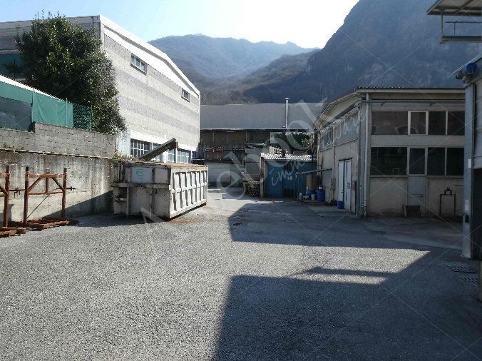 Capannone industriale ad uso produttivo con area esterna e porzione di parcheggio esterno in Valmadrera