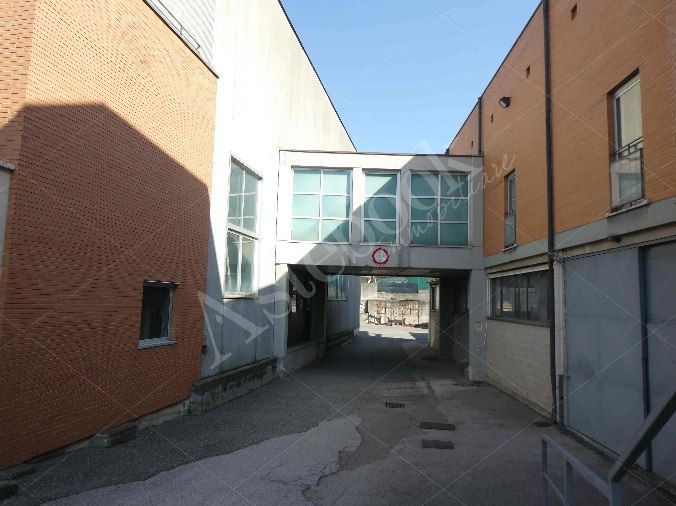 Capannone industriale ad uso produttivo con area esterna e porzione di parcheggio esterno in Valmadrera