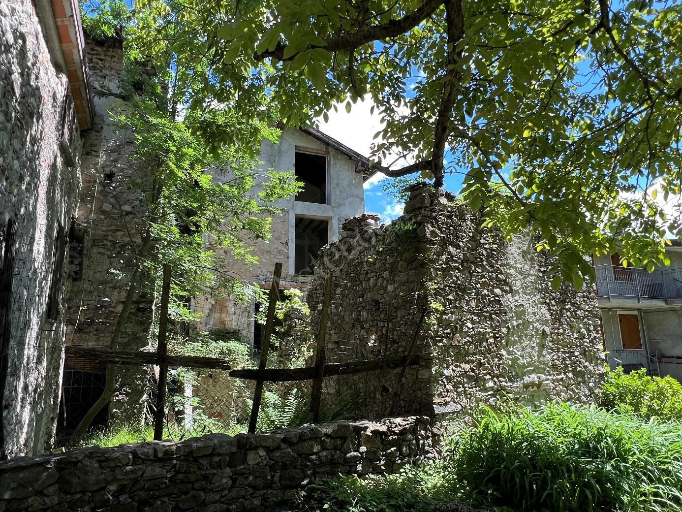 Complesso residenziale al rustico di 242 mq composto da quattro appartamenti e villetta a schiera laterale in Cortenova