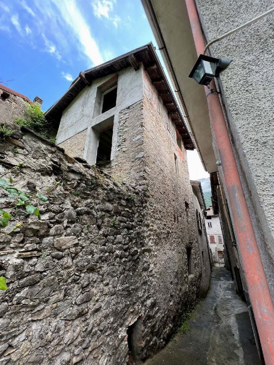 Complesso residenziale al rustico di 242 mq composto da quattro appartamenti e villetta a schiera laterale in Cortenova